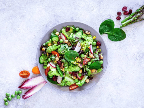 A bowl of salad with various fresh vegetables, symbolizing a healthy and balanced diet.