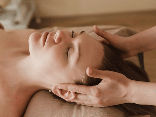 a woman lying on her back and getting a massage on her temples at YO1 Longevity and Health Resorts, Catskills