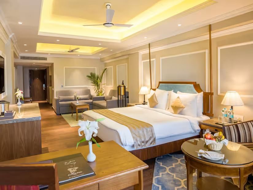 Spacious bed with wooden furniture surrounding the room for storage and relaxation.