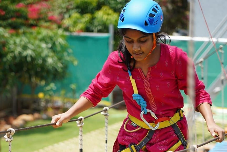 A person crossing the Tyre swing walk at GK Hill View Resort.