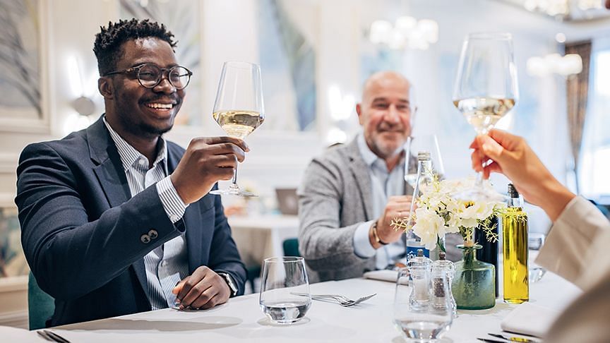 Group of people toasting at a business event in the dining area - S Hotel Kingston, Jamaica