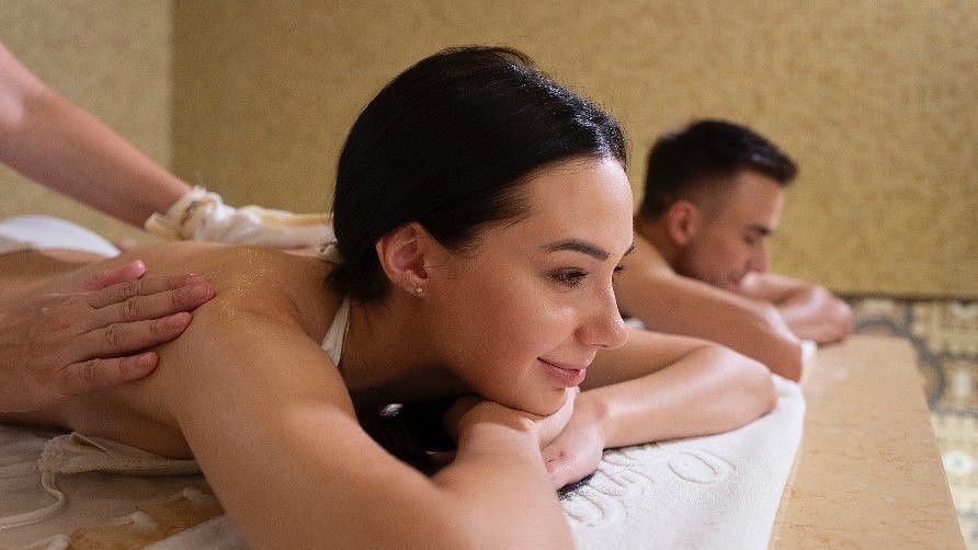 a couple on their backs getting a massage at a spa