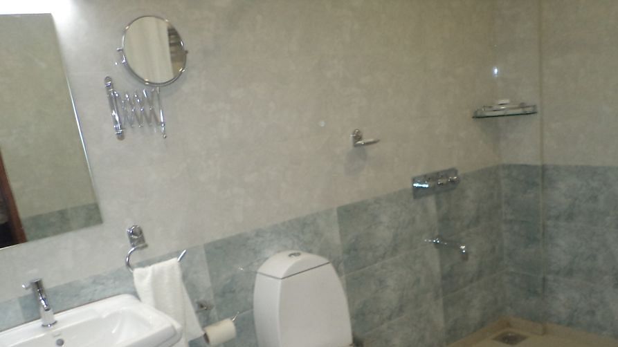 Modern bathroom with toilet, sink, and shower area