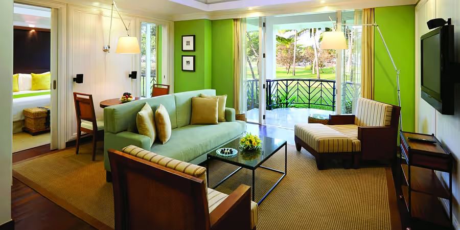 overview of a living room with sofas in front of a tv inside one of the rooms - Caravela Beach Resort Goa