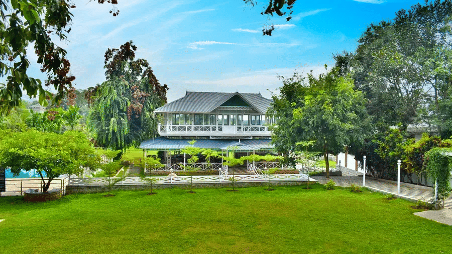 Exterior view of MGM Resorts in Yelagiri with a large green lawn and colonial-style architecture.