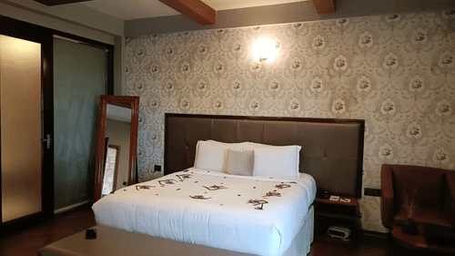 Spacious room with exposed beams, modern furniture, and natural lighting - Polo Cherrapunjee Resort