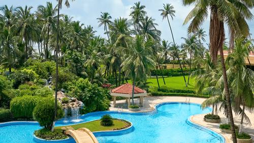 A pool area with a cabana and surrounded by vegetation.