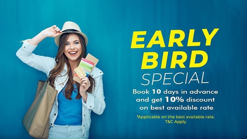 A smiling woman wearing a hat and white jacket holds travel documents against a blue background. The text reads: EARLY BIRD SPECIAL. Book 10 days in advance and get 10% discount on best available rate. *Applicable on the best available rate. T&C Apply.