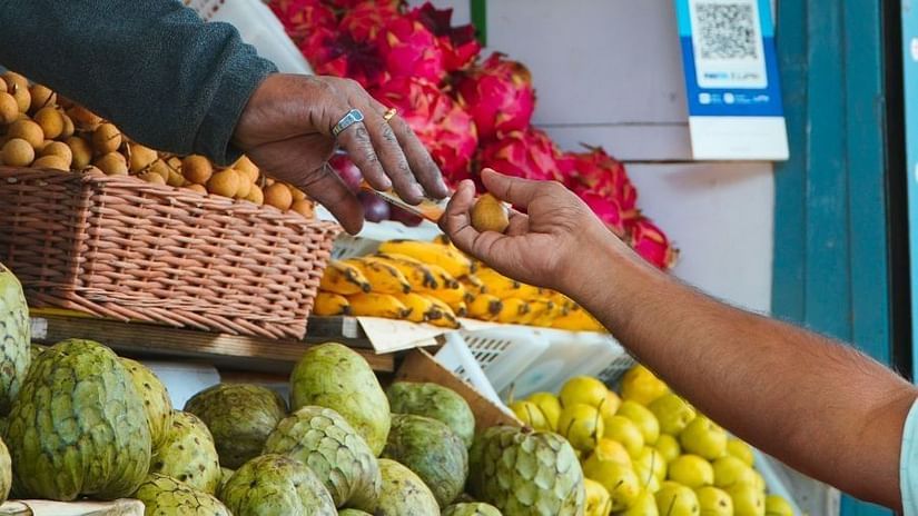 A hand reaching another hand, with varieties of fruits on the image.
