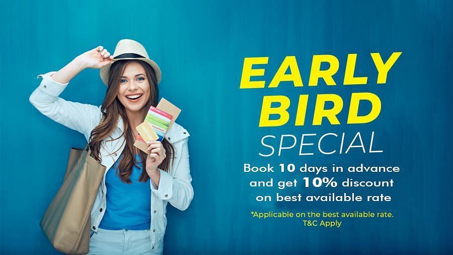 A smiling woman wearing a hat and white jacket holds travel documents against a blue background. The text reads: EARLY BIRD SPECIAL. Book 10 days in advance and get 10% discount on best available rate. *Applicable on the best available rate. T&C Apply.