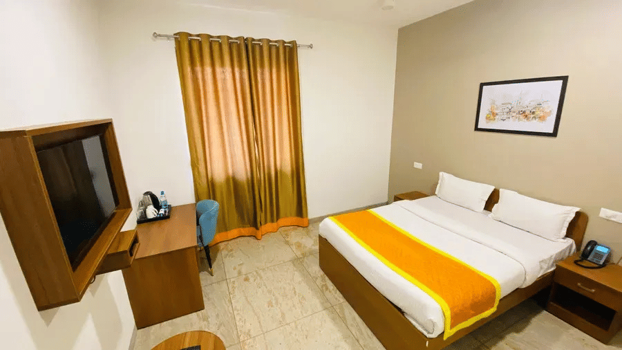 A room with double beds, pillows, sheets, and switch board.