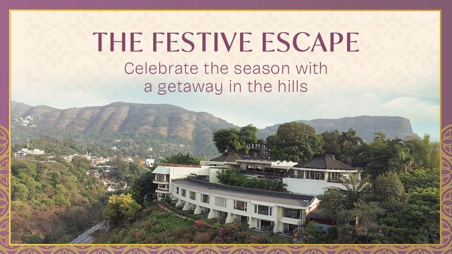 Festive campaign banner featuring a hillside hotel surrounded by greenery and mountain views. Text at the top reads - The Festive Escape – Celebrate the season with a getaway in the hills.