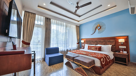 Image of Premium Room with bed and televsion at Summit By The Ganges Beach Resort & Spa, Rishikesh