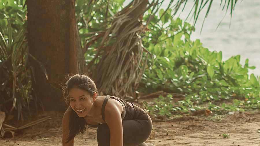 Woman in activewear smiling during an outdoor yoga session - Maikhao Dream Villa Resort & Spa, Phuket