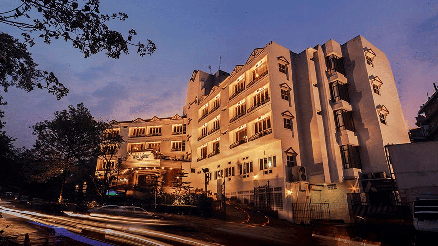 Hotel Polo Towers Shillong lit up at dusk with light trails from passing traffic.