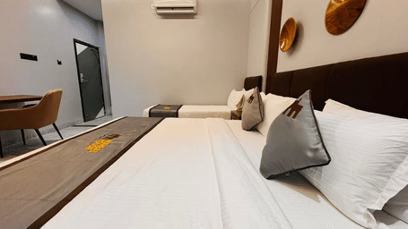 Room at Hotel Mumbai House Pithampur, with 2 beds, bedspreads, pillows, and chairs.