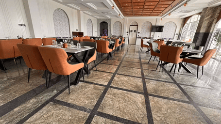 The dining at Hotel Mumbai House Pithampur, with chairs, and tables set for dining. 