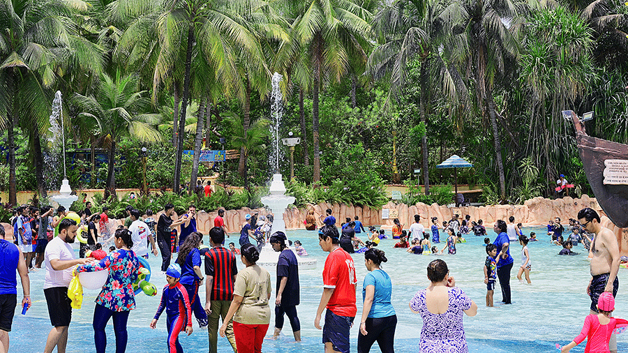 Water Kingdom - a group of people at a pool with trees surrounding at our water park