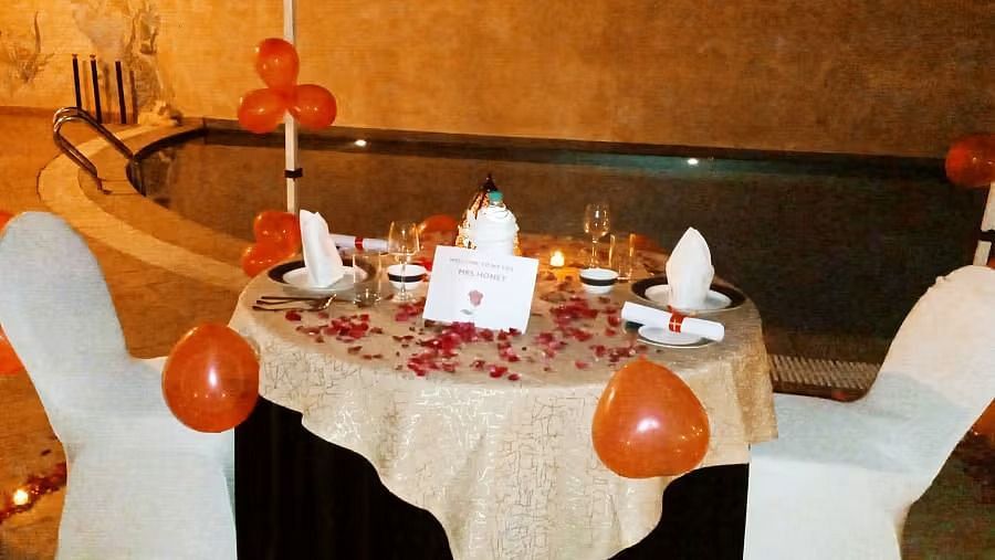 A decorated table with balloons and place settings for a celebration in a warm-toned room.