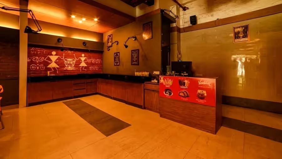 View of the entrance area with warm lighting to Mumbai Masala Restaurant - Max Hotel Prayagraj.