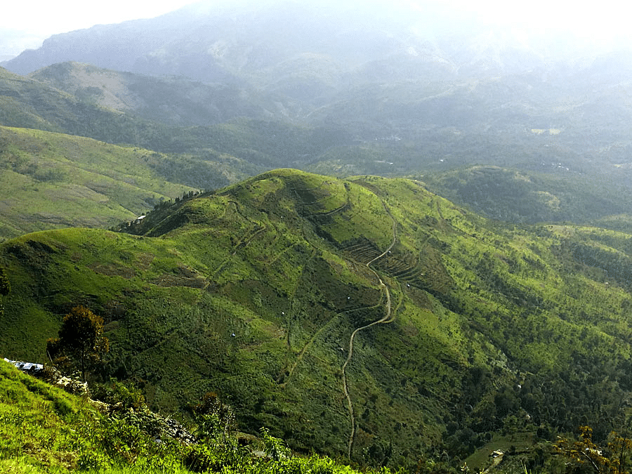 Lush green hills stretching into the distance under a cloudy sky.