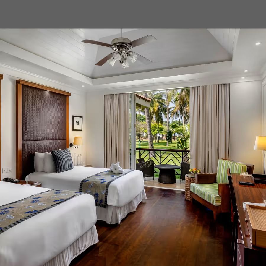 two single beds with a sofa in front of it inside Presidential Villa - Caravela Beach Resort Goa