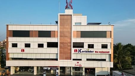 The image shows a multi-story building with signage indicating Coriander the restaurant and Lords at the entrance - Lords Eco Inn Navsari.