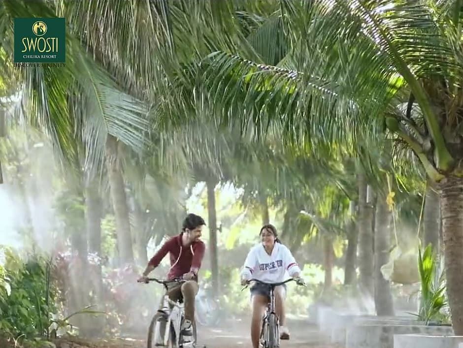 People cycling at Swosti Chilika Resort with trees surrounding them
