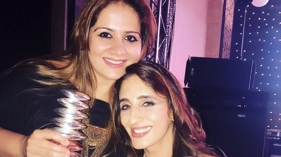 Kiran Bawa receiving an award with a celebrity - IOSIS Spa & Wellness