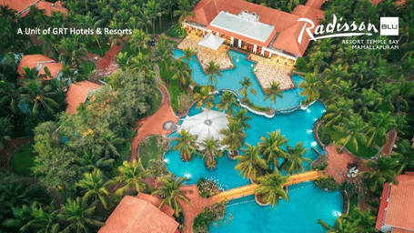 A vibrant aerial view of Radisson Blu Resort Temple Bay with palm trees, large pools and red roof cottages highlighting the Elevate at Temple Bay meeting offer.