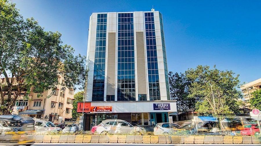Facade of Mumbai House Hotel, Juhu on a clear, blue day