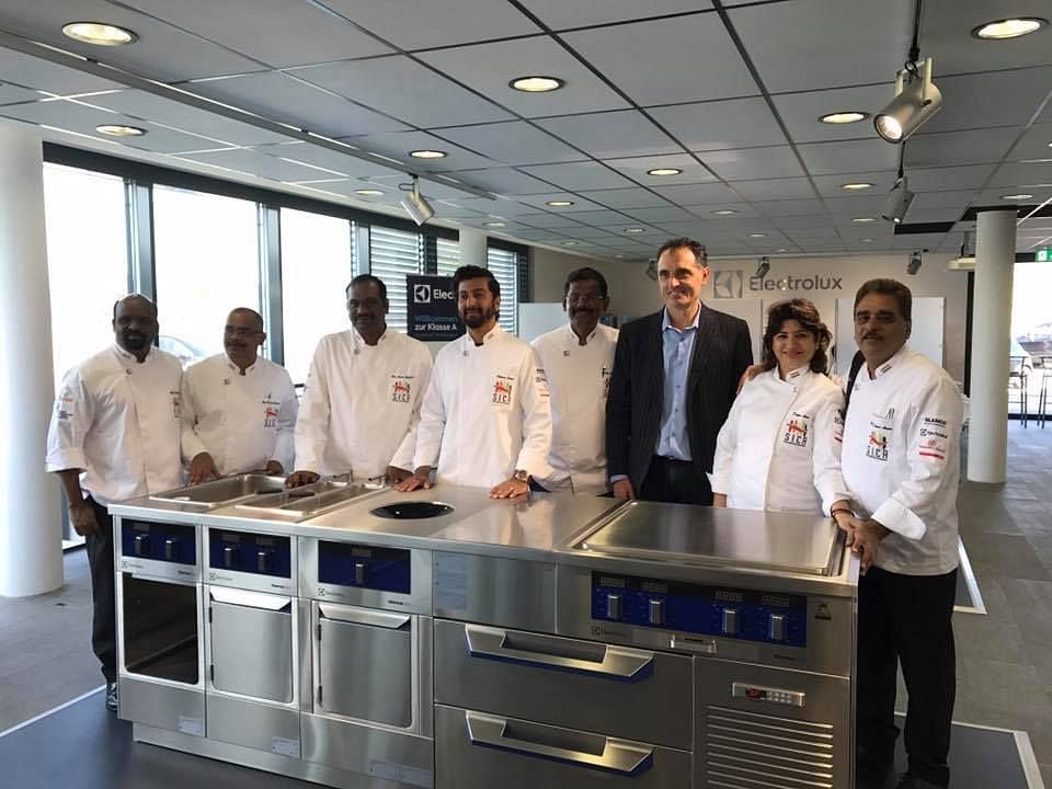 Chefs posing for a picture with the new kitchen stove.