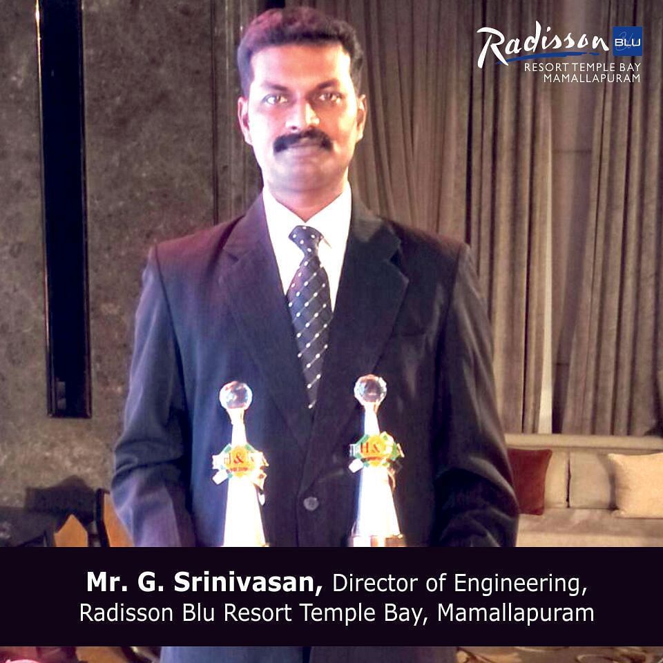 Mr. G. Srinivasan-Director of Engineering-Radisson Blue Resort Temple Bay-Mamallapuram posing with two awards in each of his hands.