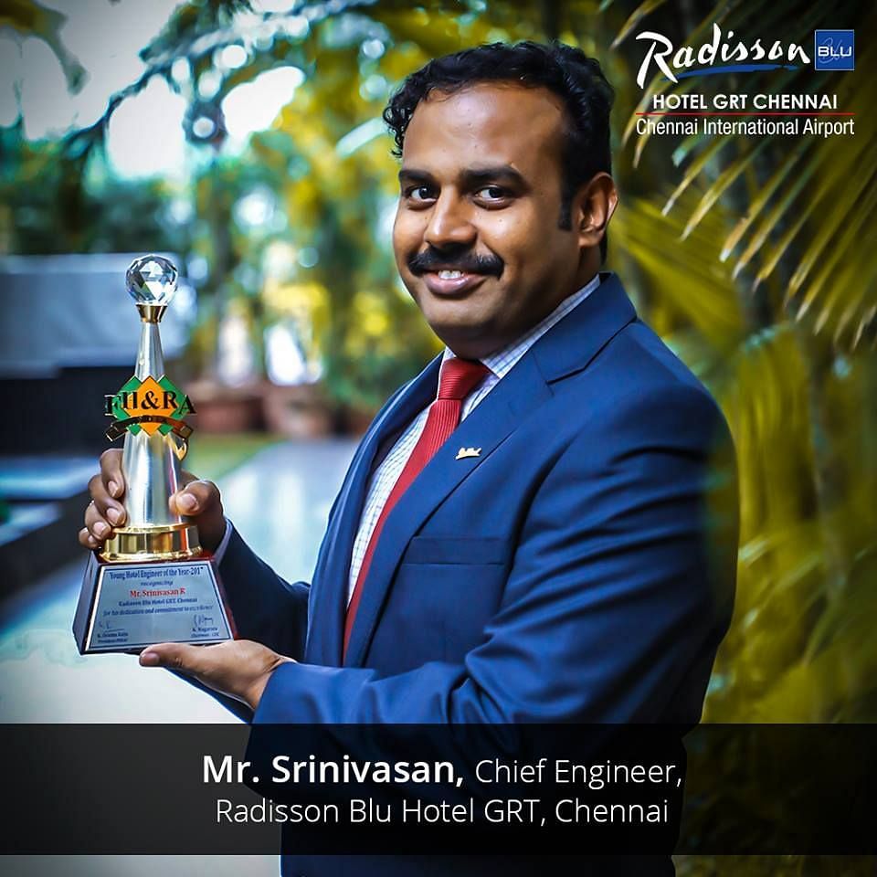 Mr. Srinivasan-Chief Engineer-Radisson Blue Resort Temple Bay-Mamallapuram posing with two awards in each of his hands.