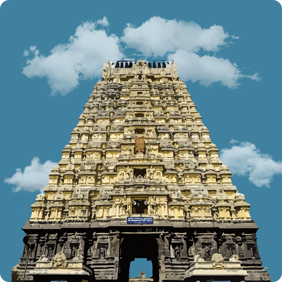Majestic gopuram of a temple adorned with intricate carvings under a blue sky.