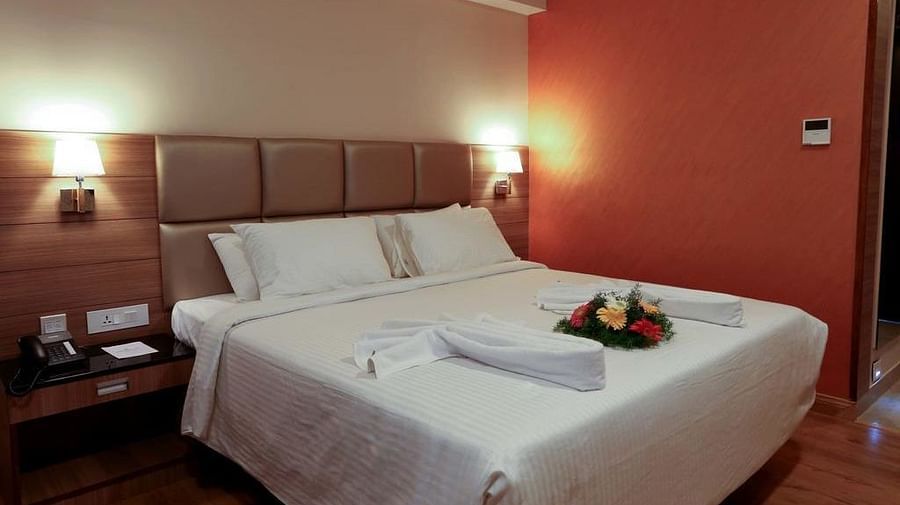 Close up view of room with flower arranged on the bed wit a side table at Fressotel Seetharam, Coimbatore