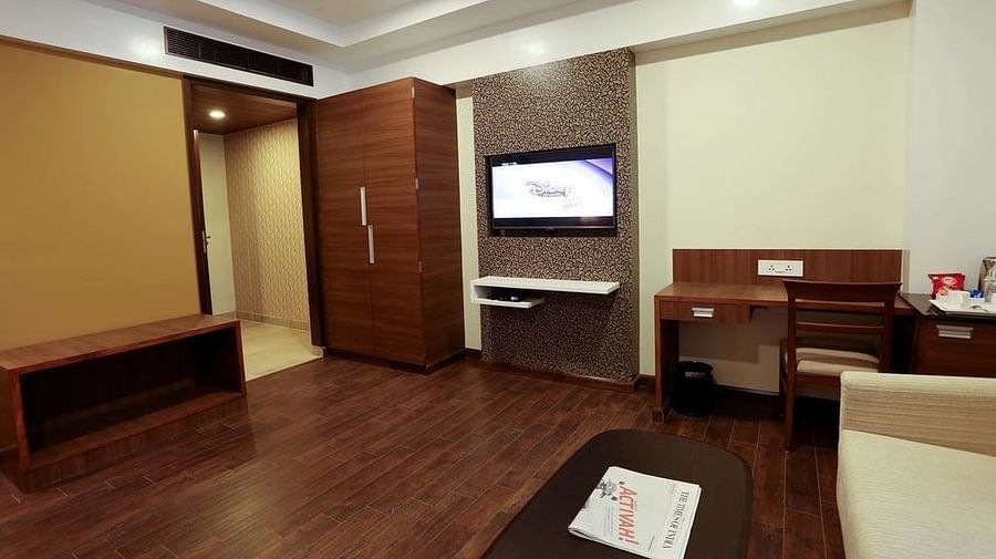 Sapcious room with wooden flooring, wooden wardrobe and study area at Fressotel Seetharam, Coimbatore