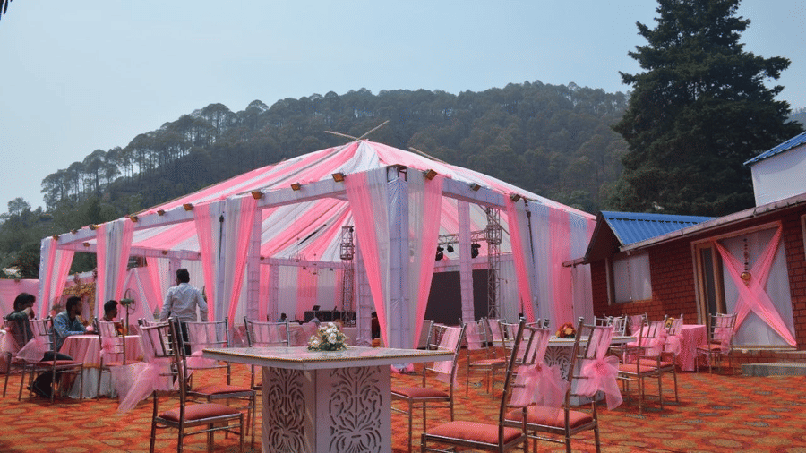 A decorated venue with chairs, and table, with a view of the hills on the background.