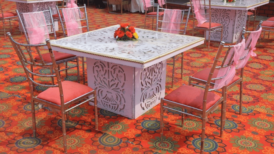 Chairs arranged around a square table on a floor with design
