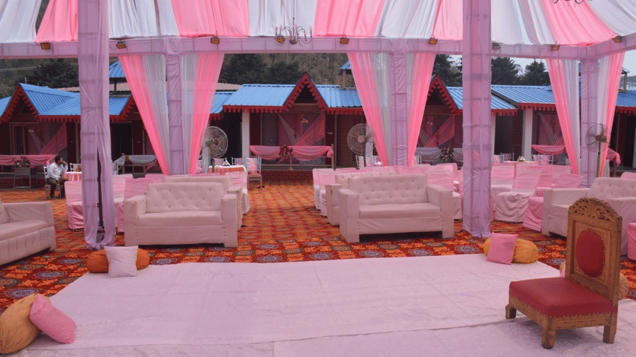 Decorative venure for an event, with cloth decorated seats, pillars, and a small chair