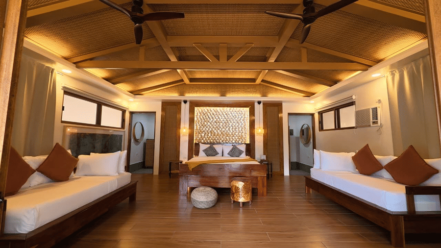 Flower Island Resort | A room with three large beds, pillows, spreads, and lights.