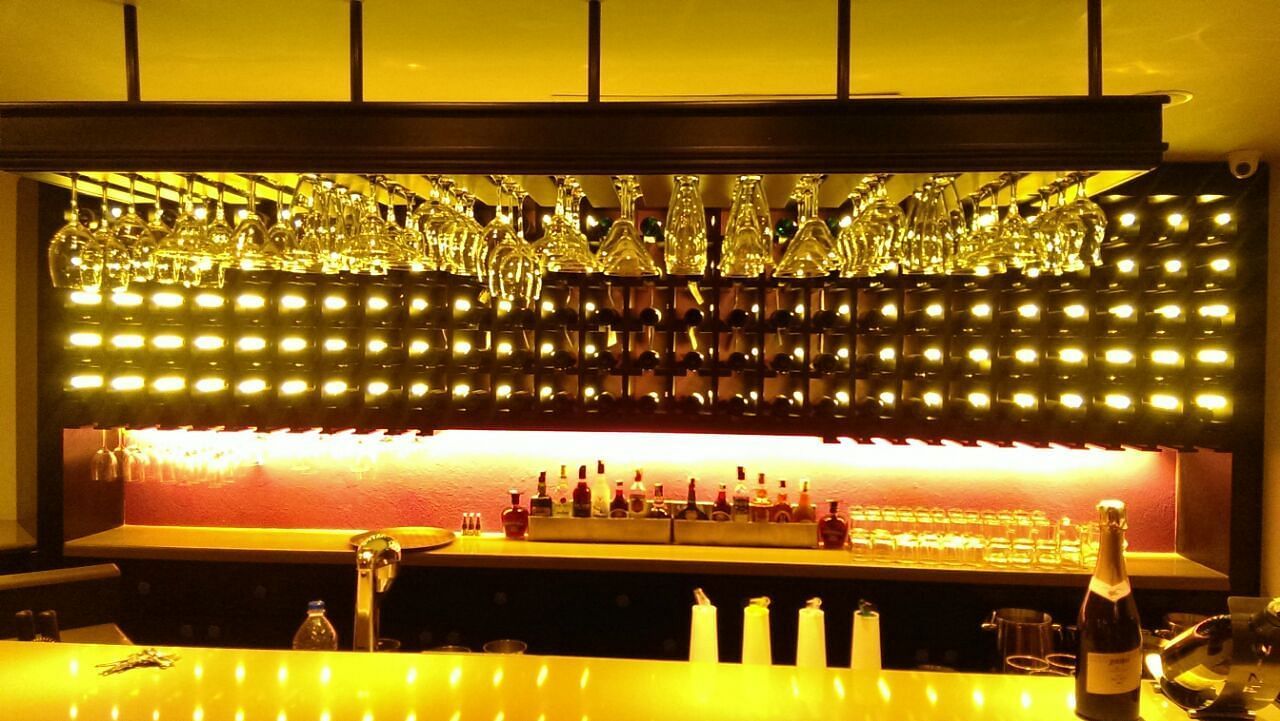 Bar area with glasses and bottles, featuring lighting set for relaxation