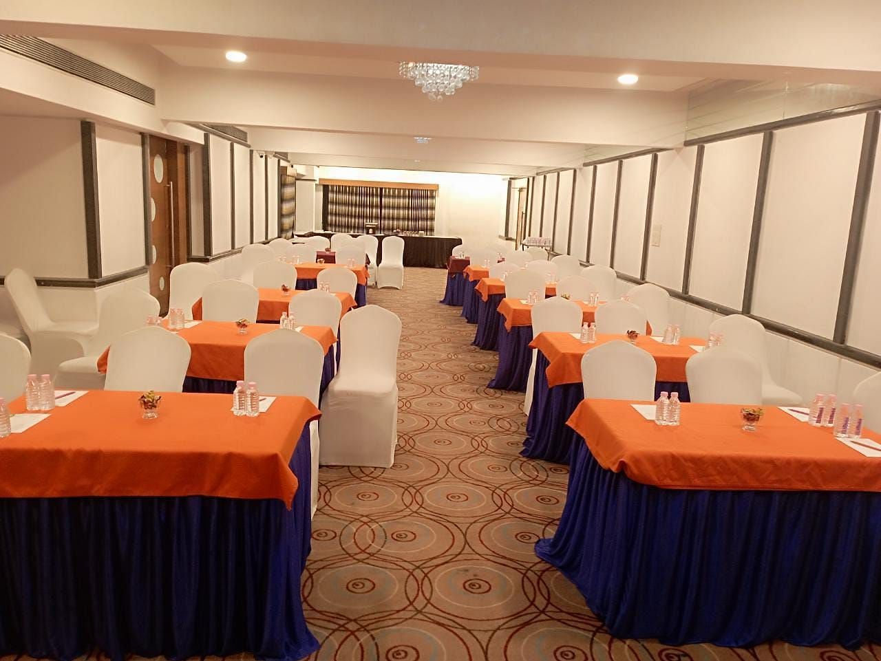 Event hall at Rang Lords Inn, set up with rows of chairs and decorated tables, prepared for a meeting or celebration
