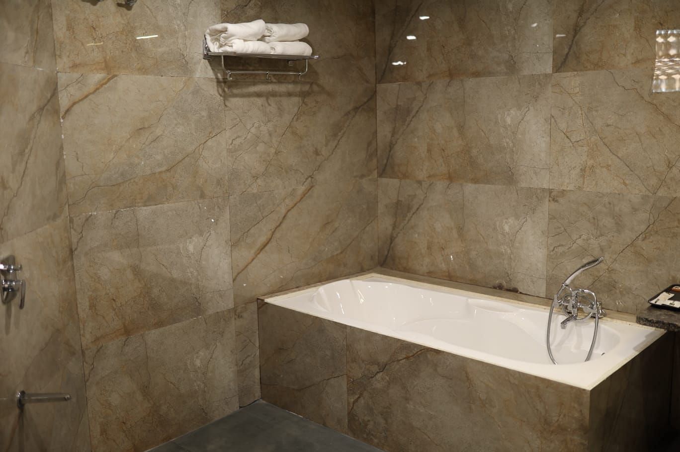 A close-up shot of a modern bathtub with a white interior and a light-coloured marble surround - Bamboo Saa Mulberry Resort, Pushkar