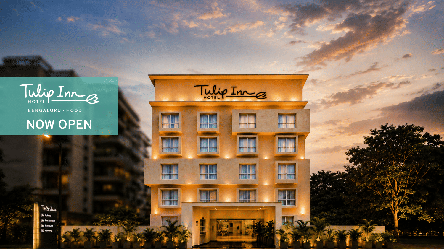 Website banner of Tulip Inn, Hoodi Whitefield, Bengaluru, showcasing the property facade, with the signage reading 'Tulip Inn', a 'Now Open' block, and a partially cloudy sky in the background.