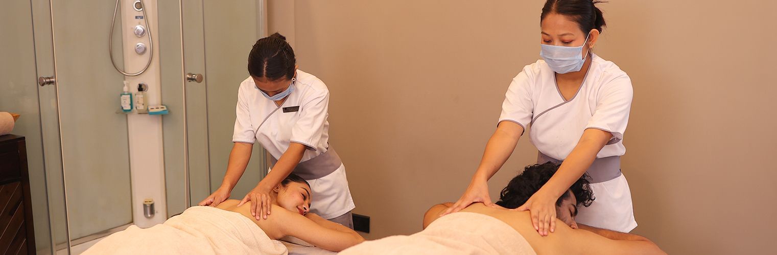 2 masseuses offering a couple a massage in the spa at Polo Hotel Agartala.