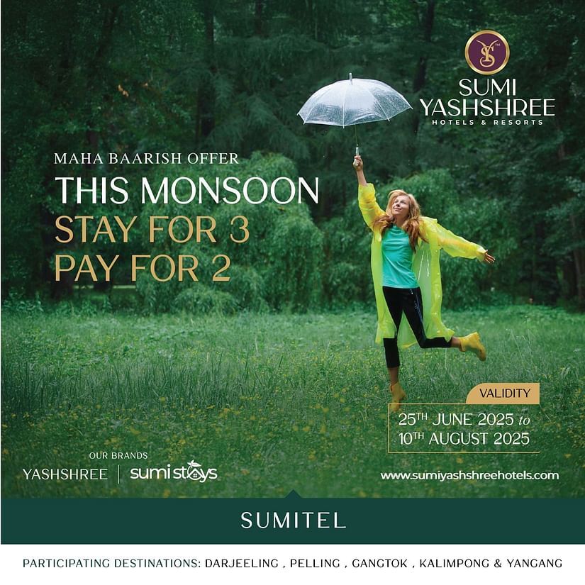 Woman joyfully jumping in green field under umbrella, highlighting Sumitel’s monsoon deal – stay 3 nights, pay for 2.