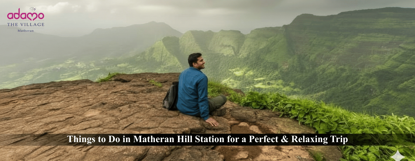 A panoramic view of a person sitting on a rocky cliff overlooking the lush green, misty valley of Matheran Hill Station.