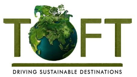A logo of TOFTigers which is a driving sustainable destination. The Logo has an earth with most part covered in green grass and the animal silhouette is also made of green grass.  