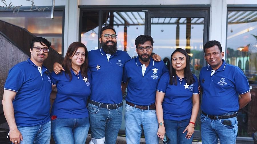 A group of employess in blue polo towers tshirt posing - Polo Towers